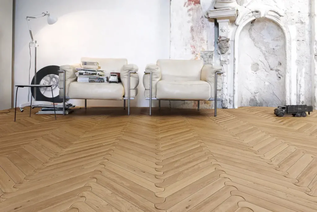 A living room with a light brown chevroon wood floor