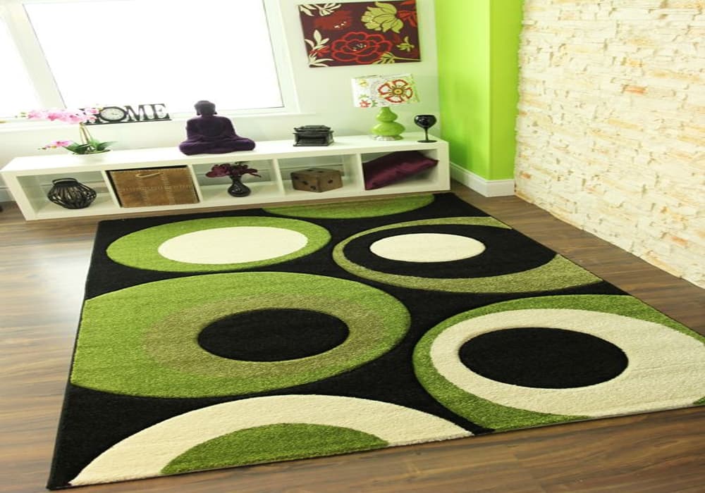 A large, circular rug with shades of green, black, and white